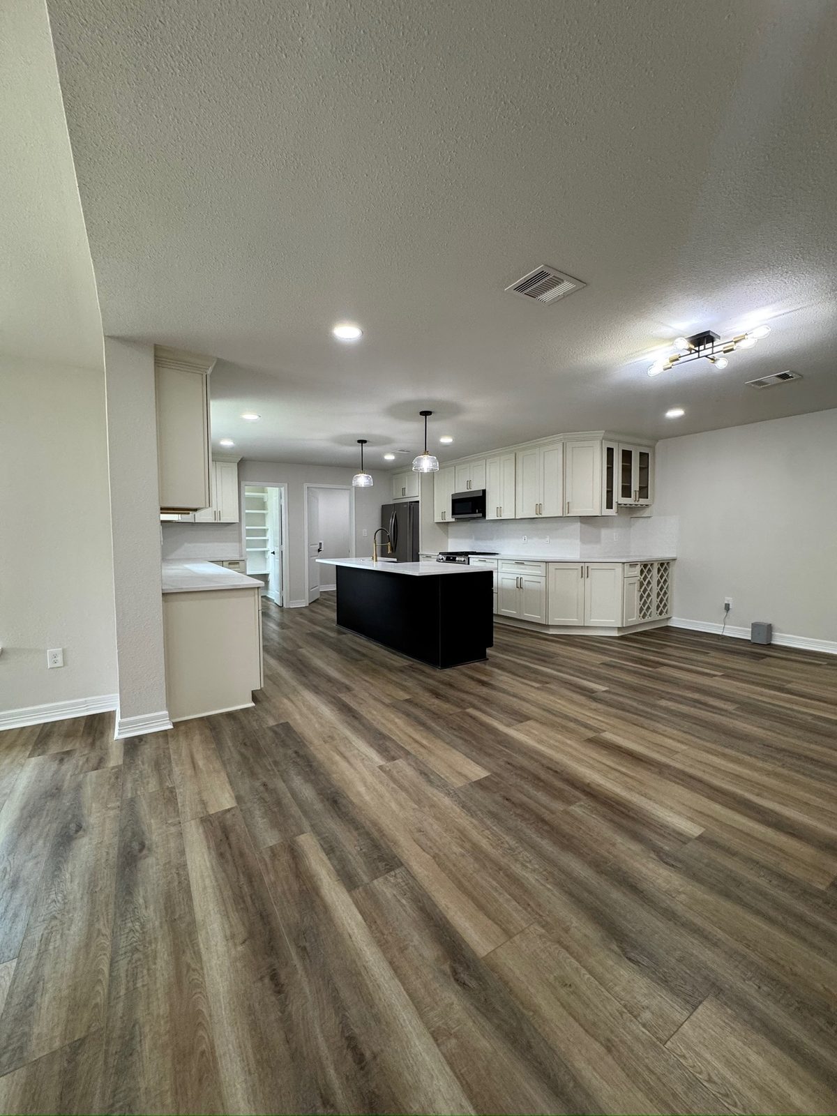 Finished open-concept kitchen with black island and quartz countertops